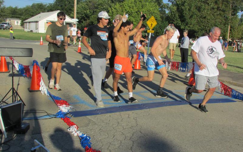 Wrestling Coach Barry Patterson has the whole wrestling team cheering him on as he completed the Grappler’s Gallop which was held on Sept. 30 prior to the opening of the annual Festival in the Park.
