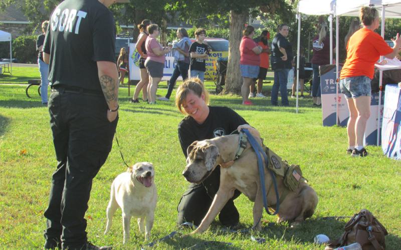 Core Civic employees Kristin Prichard and Kyle Bennett greeted booth visitors with their K9 companions — Nube and Gino.