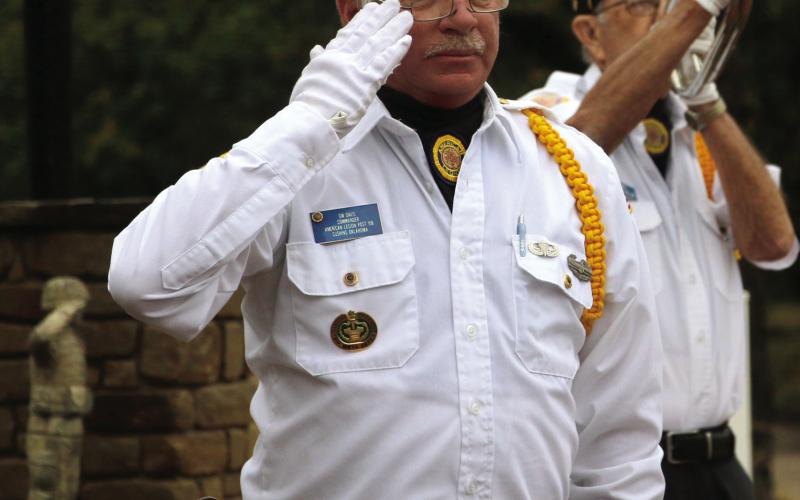 Legionnaire GW Davis salutes as Robert “Chef” Howell plays taps during the flag retirement ceremony at the Donaldson/ Walker Cushing-Drumright American Legion Post 108 Oct. 25. Photo by Allie Prater