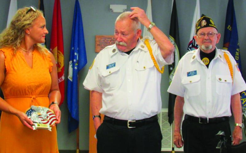 Maria Roberson stands with Commander Dennis Fisher and Robert “Chef” Howell after having been presented with a plaque of recognition.
