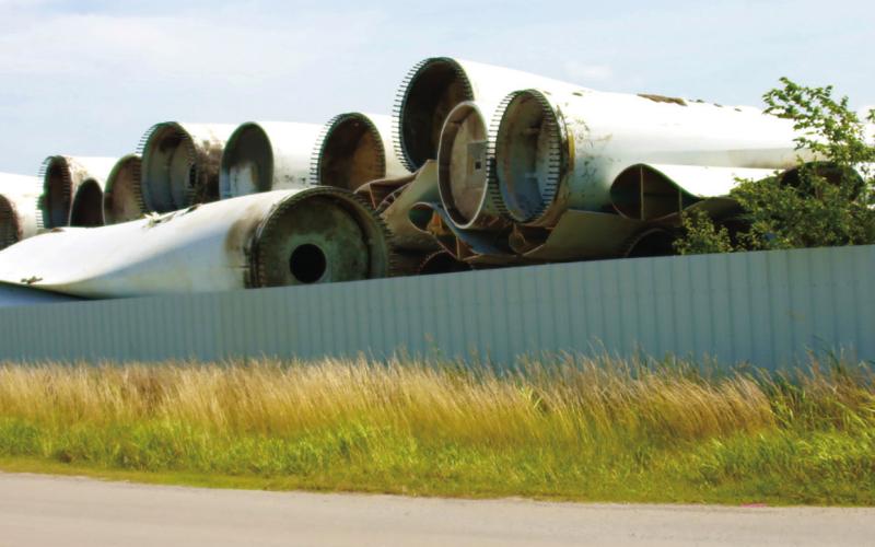 Hundreds of discarded wind turbine blades stacked like cordwood at a site south of Cushing await their fate. Photo by J.D. Meisner