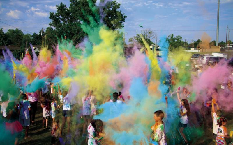 Cushing Geographic Club Color Fun Run participants and volunteers throw at remains of colored powder into the air Saturday at the close of the run, which is the club’s main fundraiser. More photos, Page A6.