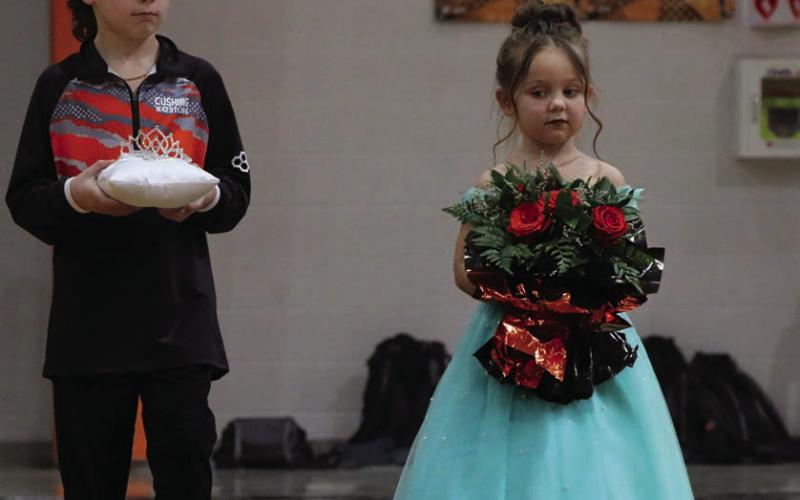 Crown bearer Easton Wright, 8, and flower girl Walker Shoemaker, 5, trail the procession of homecoming candidates. Photo by Allie Prater.