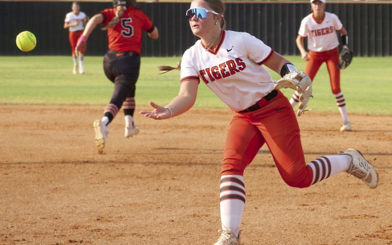 Freshman Lady Tiger Gracie Morphew throws to first to attempt to get an out on a Davenport Lady Bulldog during the Lady Tiger’s season opener Monday, Aug. 10. Photo by Allie Prater.