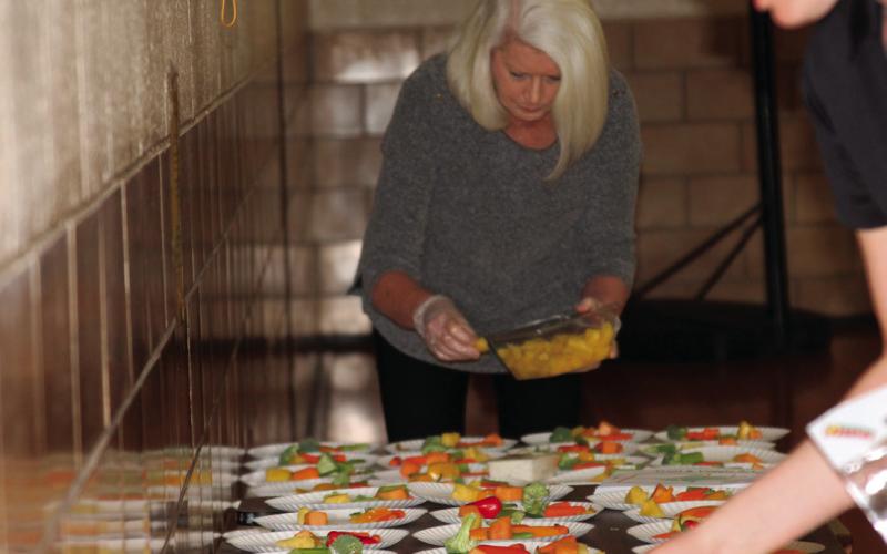 Nancy Dowell helps position produce on a plate during a Healthy Living Oklahoma event at Harmony Elementary before Cushing Elementary Center was completed.