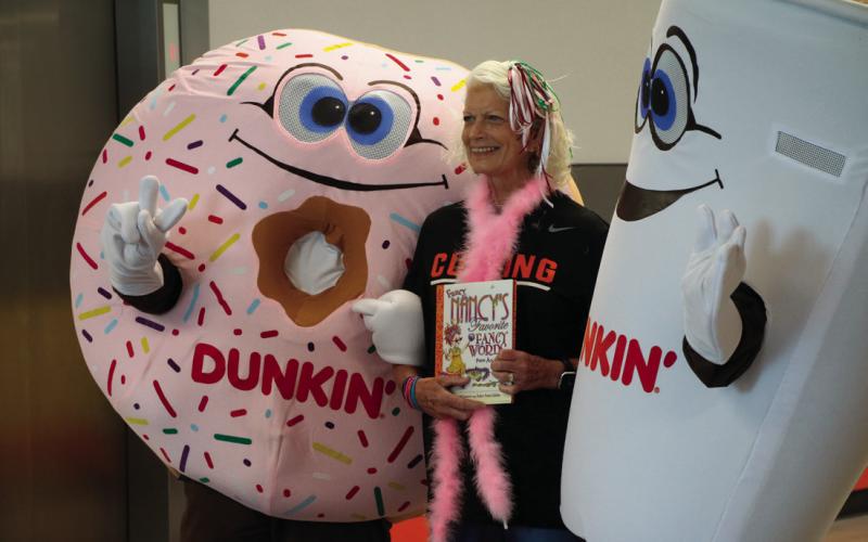 Fancy Nancy Dowell stands with Cuppy and Sprinkles, the mascots of Dunkin Donuts after the Cushing Elementary Parade of Book Characters last fall.