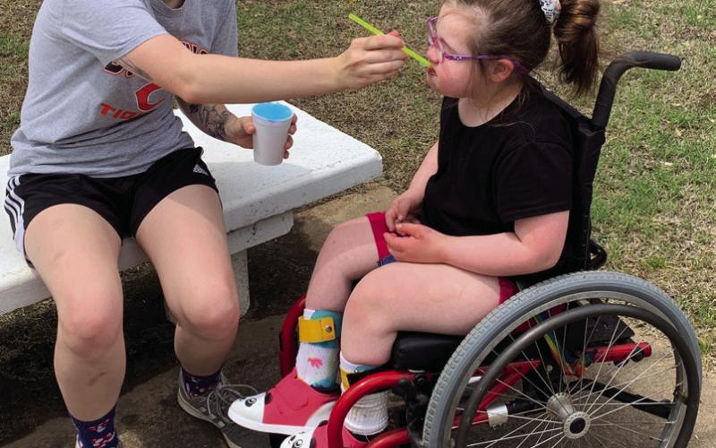 Above: Rhonda Griffith supervises as Jagger Simpson, Ganon Hatfield and Bayden Huckabay play on the jungle gym during the Cushing Lower Elementary Field Day festivities. Left: Portlynn Williams and Harper Shidler enjoy a blue snow cone from Chilly Willy’s.