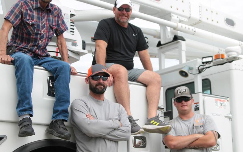Dub Hargrove and his son Joe, and Doug Biswell and his son Taegan work together at the City of Cushing’s Electric Distribution Department. Photo by J. D. Meisner