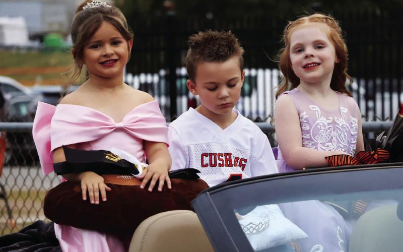 Flower girl Montana Ivy Cloud, crown bearer Bowen Loftis, and flower girl Lylah Beasley ride onto the field in style.
