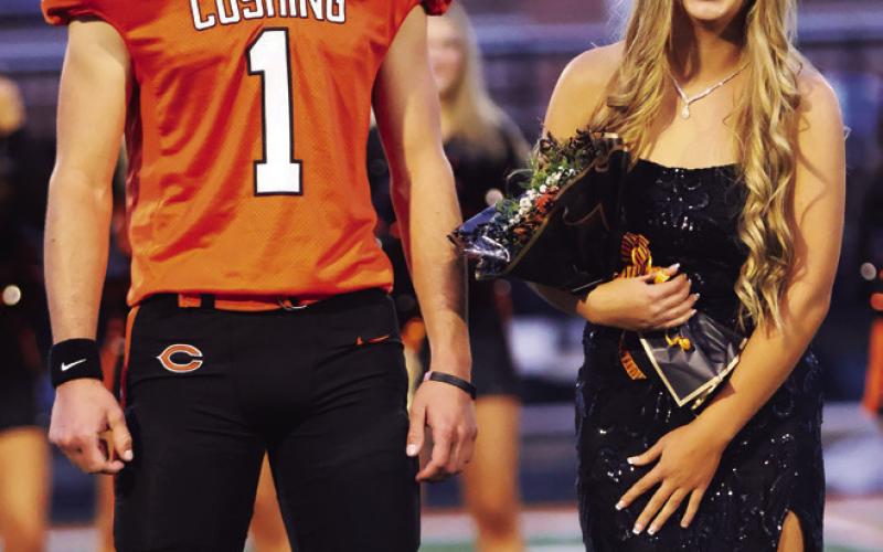 King candidate Roman Tucker escorts queen candidate Clara Deaton.