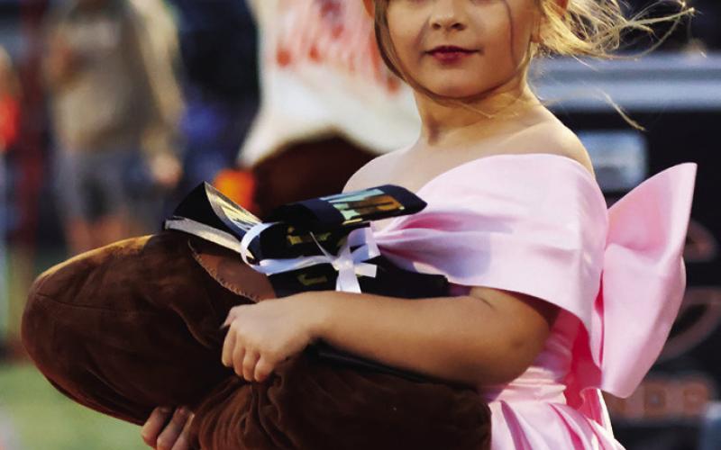 Right: Flower girl Montana Ivy Cloud walks onto the field.
