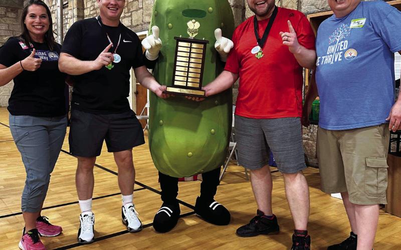 Payne County United Way Executive Director Ruth Cavins, left and Mercury Marine Procurement Director Brian Price, right, present Joe Bickell and Geoff Beasley with their championship trophy during Mercury Marine’s Fourth Annual Pickleball Tournament held Nov. 10 in Stillwater. Proceeds from the event went to Payne County United Way.