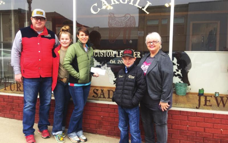 Pictured with the new sign on the windows of their new shop are Justin and Brooke Cargill with their daughter Mercedes and son Beau. At right is DCRA Treasurer Beth Dutton.