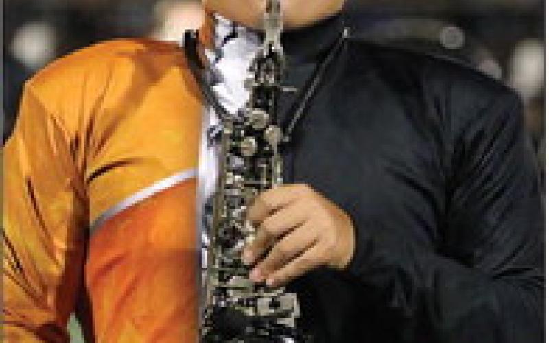 Cushing Tiger Marching Band saxophonist Luis Quezada performs a solo during the halftime performance at the Tiger’s home opener.