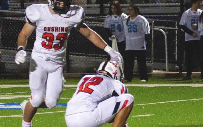 John Hilligosholds while Cushing’s Riley Matheson sends another PAT through the uprights. photo by J. D. Meisner