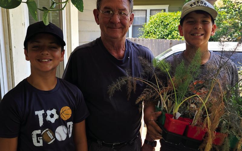 Local resident John Moran is pictured in the middle of Adrian Casteel and Jaxon Bell after donating plants for the Keep Oklahoma Beautiful project that Bell initiated.