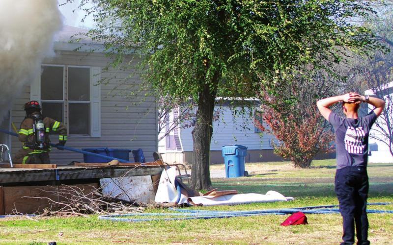 The grandson of the owner of this home on Greenlee watches distraught, as members of the Cushing Fire Department work to extinguish the fi re inside the building.