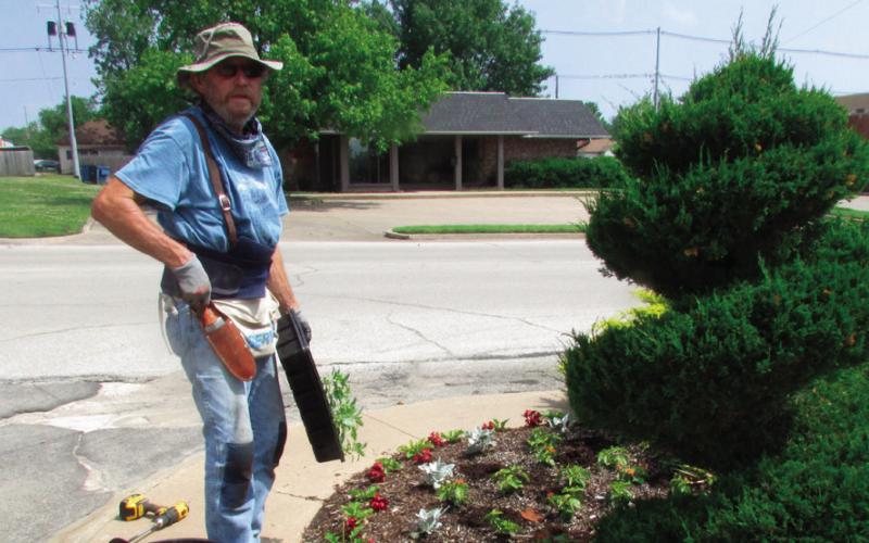 Ben Welch works on the plant beds on the north side of BlueSky Bank. Photo by DeAnna Maddox