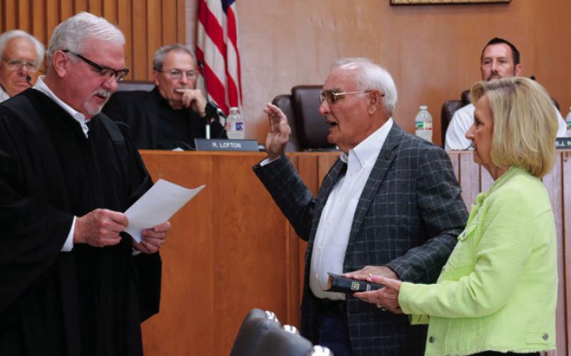 Winetta Lamb holds a family bible for her husband Ron as Municipal Judge Bill Ahrberg administers the oath of office to newly elected commissioner Ron Lamb. Photos by J.D. Meisner