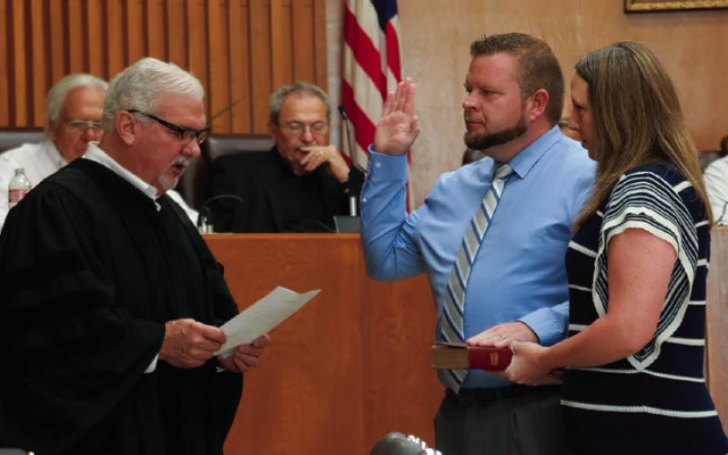 Dawn Beasley holds the family bible as her husband Geoff Beasley takes the oath of office from Municipal Judge Bill Ahrberg.