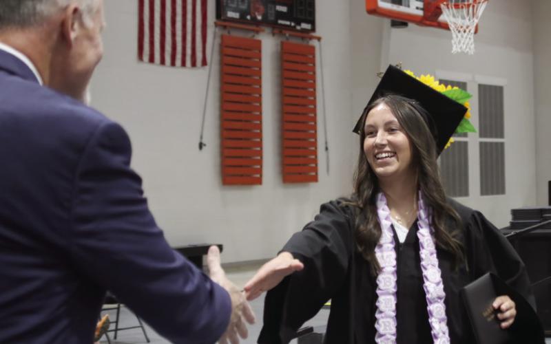 Amber Fausto shakes hands with CHS Principal Bob Coates after receiving her diploma.