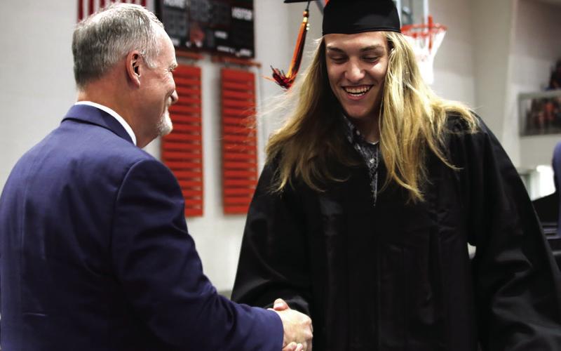 Bob Coates congratulates graduate Jasper Skelnik.