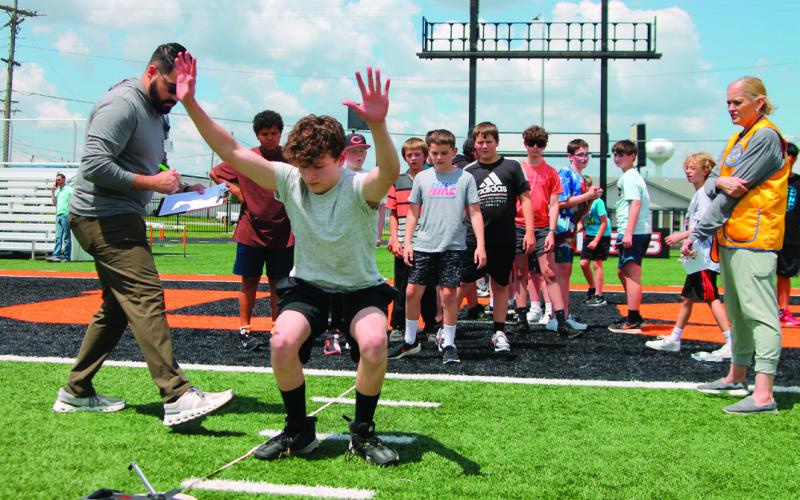 Sixth grade student Nolan Wiley finds his balance after making his first long jump during Junior Olympics last Friday on May 9. He placed second in the event.