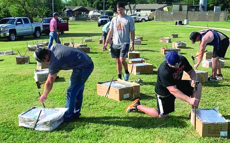 Tyson Rivas, Danny Karlin, David Gilley, and Dylan Taylor place stakes next to the pyrotechnics to hold them in place. Photo Courtesy Mark Beitz