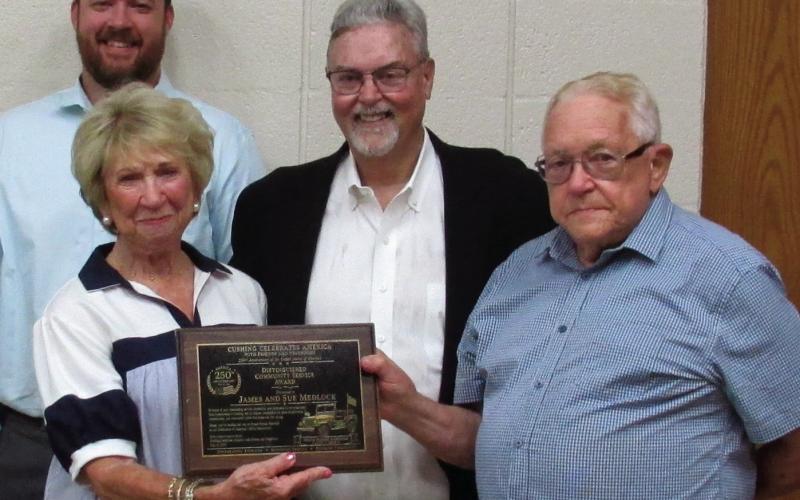 Grand Marshals Sue and Jame Medlock stand with Mike Kennedy after being recognized for years of community engagement.