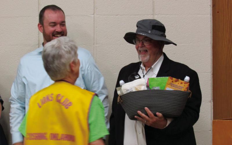 Mike Kennedy looks gleeful as he tries on a new hat that was presented alongside a basket of goodies as the recipient of the surprise Caring for Community award.