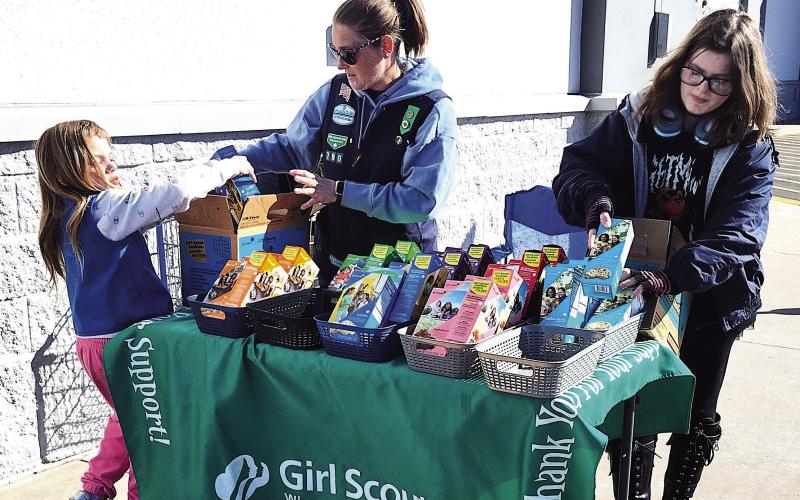 Local Girl Scout Troop 790 set up to sell cookies just outside Wal-Mart Sunday, Feb. 22, offering classic favorites to passersby during the annual cookie season fundraiser. Pictured from left: RayLynn Floyd, Troop Leader Rebecca Green, and Alice Green. Photo by DeAnna Maddox