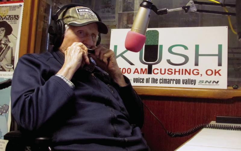 Don Wilbur plays the harmonica in the studio of KUSH Radio. Photo by DeAnna Maddox