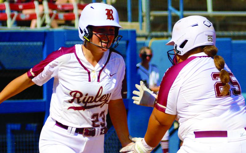 Brook Gambill congratulates Cougar Pool on her hit as she trades off with her as pinch runner.