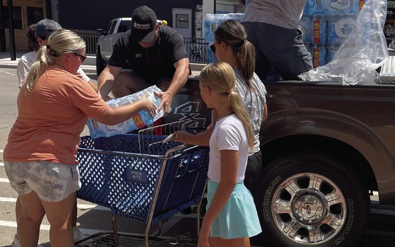 Rotarian John Rhoten and other community volunteers unload a pallet of water at the Cimarron Towers in Downtown Cushing Tuesday, Aug. 6. Photo courtesy Nancy Dowell