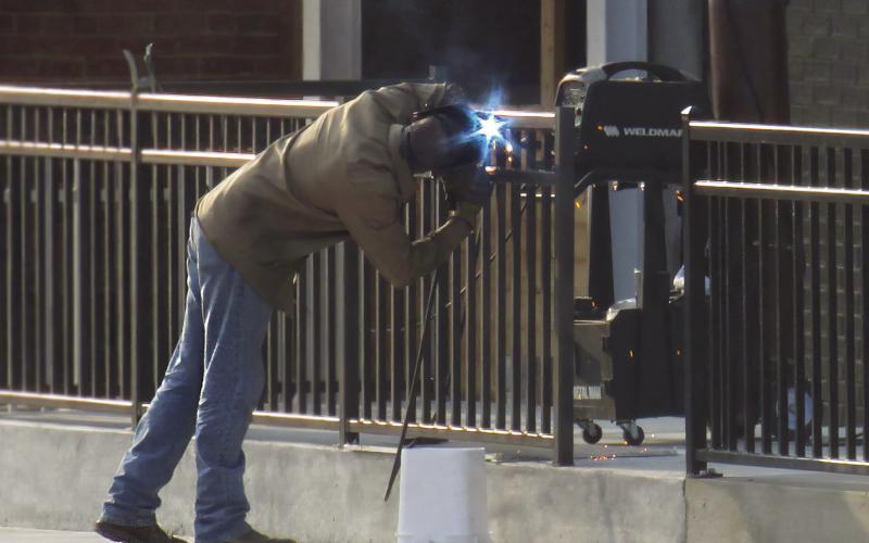 A welder works on the railing of the outdoor patio of Godofredo’s Thursday, July 25. This is part of a larger expansion project that has been ongoing in Downtown Cushing for several weeks. Photo by DeAnna Maddox.