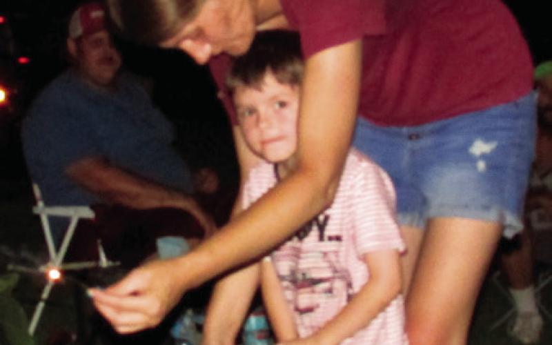Shannon Cullie holds a sparkler for Corbin Cullie to admire prior to the firework display at Cushing Memorial Park.
