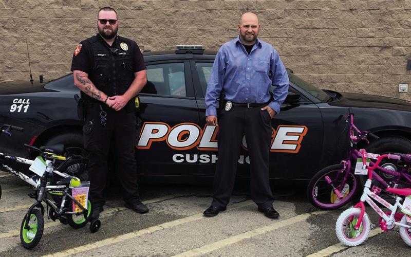 Cushing Police department Officer Wright and Detective Livergood stand with the first four bicycles purchased for the upcoming Bicycle Rodeo.