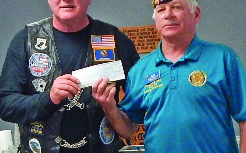 Brett Martin, director of the American Legion Riders, presents a certificate of appreciation to American Legion Post 108 Commander G.W. Davis while Davis presents the Riders with a donation to support the Veterans &amp;amp; Children Foundation of The American Legion during a May 17 stop in Cushing. Photos by Evelyn Ferchau.