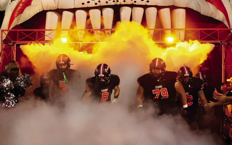 Lane Simpson, Jordan Kersey, and Tye Lucio emerge from the fog, leading the Tigers onto the field Friday for the last regular season home game. Photo by Sylvia Danyele.