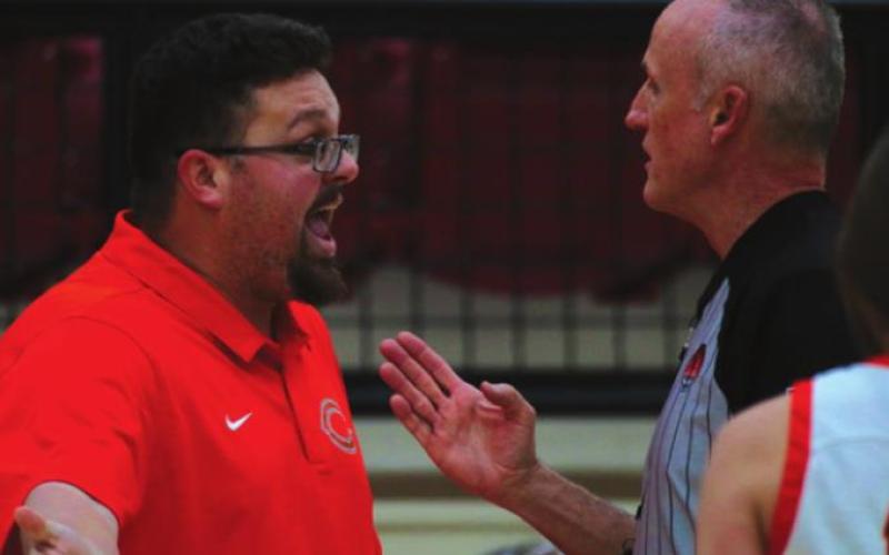 Lady Tiger Head Coach Jake Phillips discusses the fi ner points of putting air in your whistle with a game offi cial during the opening round of the Cleveland Tournament.