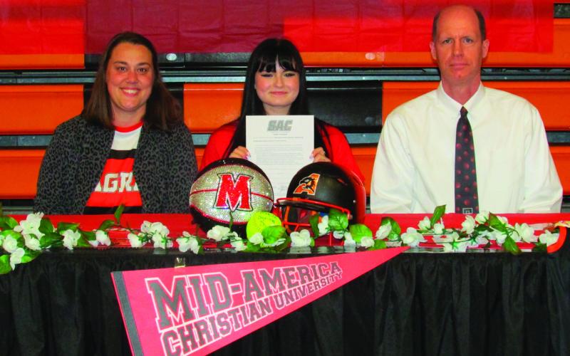 Rylie Pendergraff holds her intention letter for softball and basketball at MACU sitting next to high school softball Coach Leslie Rollins and high school girl’s basketball Coach Chad Dickerson.