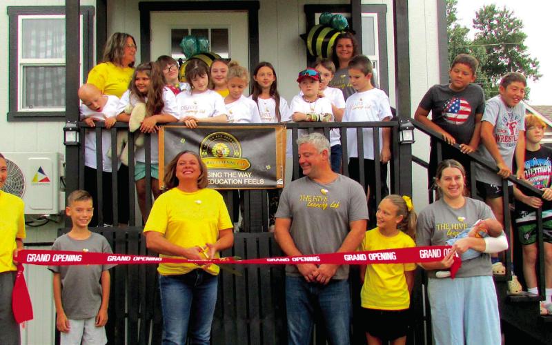 Stevphanie Thurber cuts the ribbon in front of The Hive Learning Lab students and staff marking a milestone for the group. She stands in front with her family — from left; Kinzey Myers, TJ Thurber, Stevphanie, Terry Thurber, Addie Thurber, and Kaylea Ballard.