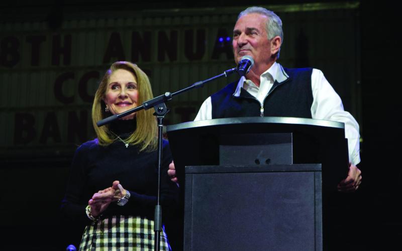 Husband and wife share a laugh with the crowd as Kris Kinzie reads through Denise Kinzie’s favorite quote from Margaret Thatcher: “If you want something said, ask a man; if you want something done, ask a woman”. Photo by DeAnna Maddox