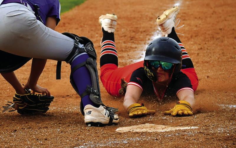 Lady Tiger slow pitch Freshman Alyssa Roe dives into home plate against Hominy last week. Photo by Sarah Townes