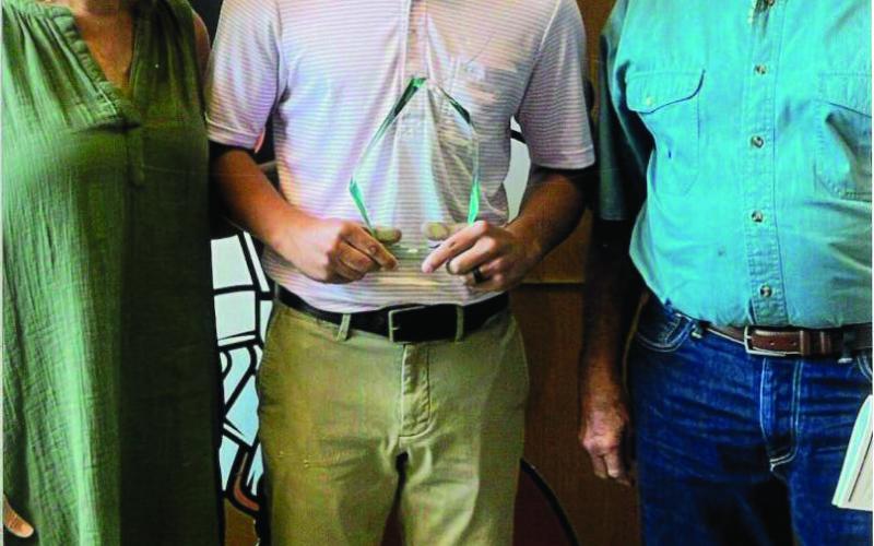 Tricia and Ray McGinnis present Coleton Dallas the Scott A. McGinnis Memorial Scholarship.