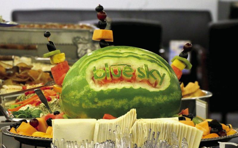 A watermelon carved with the BlueSky Bank logo sits at the head of the buffet during the Business After Hours hosted by BlueSky Bank Tuesday, Aug. 6.