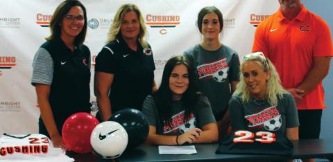 Recent Cushing graduate, Ashlynn Arnce, signs her letter of intent to play soccer at North Arkansas College on Monday at Cushing high school surrounded by family and her former coaches. Photo by Kaleb Tadpole