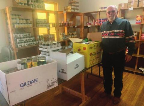 Ted Wilson of Drumright stands in front of shelves fi lled with donated canned goods at the Drumright Food Pantry.