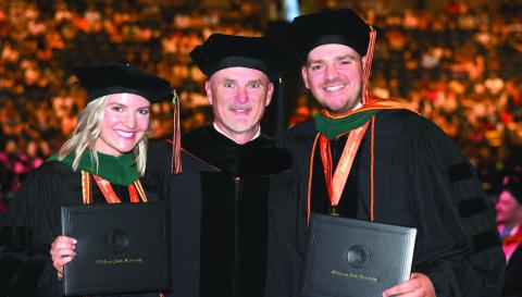 Brooke Gardner and Bingham Hightower stand with their father, Dr. Brian Hightower, between them after they officially earn the title of doctor themselves. Photo courtesy Dr. Brian Hightower.