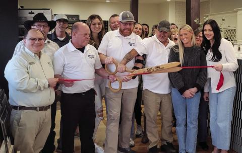 Members of the Cushing Chamber of Commerce surround the owner of Precision Flooring at the ribbon cutting held Friday, Nov. 17.